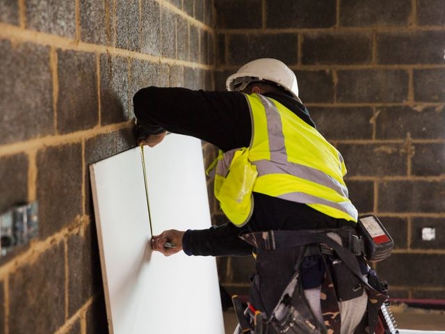 Builder measuring a board
